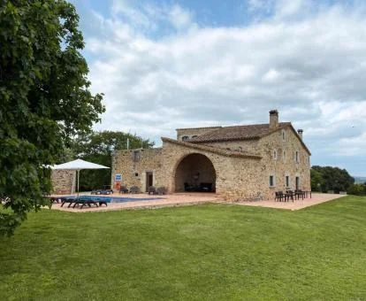 Hotel rural con amplias zonas exteriores ajardinadas y piscina.