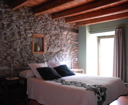 Una de las acogedoras habitaciones con paredes de piedra a la vista de este hotel rural.