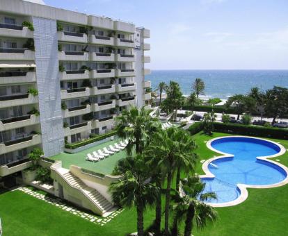 Edificio de este hotel con encanto con piscinas y vistas al mar.