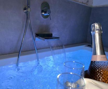 Bañera de hidromasaje en funcionamiento con botella de cava de una de las habitaciones del hotel.