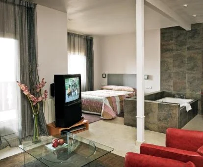 Preciosa suite con bañera de hidromasaje cerca de la cama.