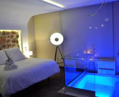 Espectacular dormitorio con bañera de hidromasaje privada junto a la cama en la villa Deluxe.