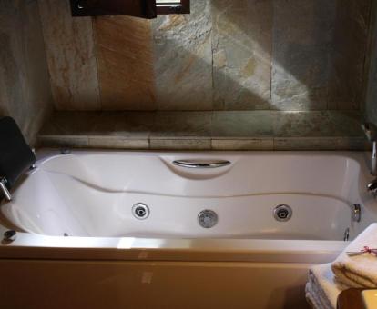 Bañera de hidromasaje privada en el baño de la Habitación Doble Deluxe.