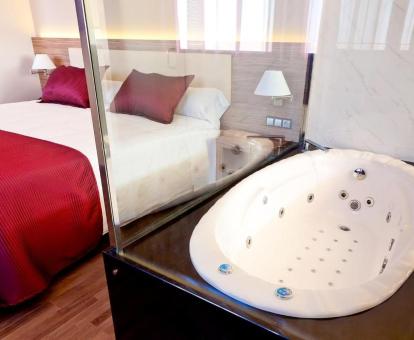 Bañera de hidromasaje privada junto a la cama en la Habitación Doble Superior con vistas a la laguna.