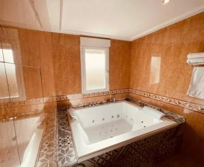 Fabuloso jacuzzi para dos personas de la suite del hotel.