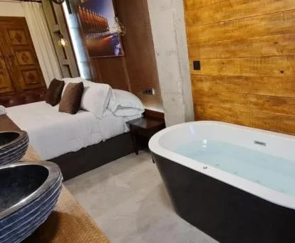 Habitación Doble con bañera de hidromasaje cerca de la cama.