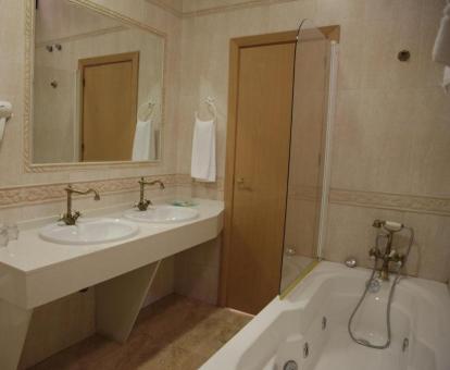 Baño con bañera de hidromasaje privada de la Habitación Doble Deluxe del hotel.