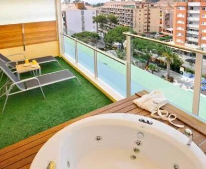 Terraza con tumbonas y jacuzzi exterior de la suite junior del hotel. 