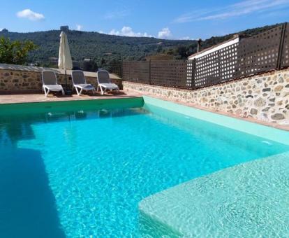 Acogedora piscina exterior con tumbonas y vistas de este hotel con encanto.
