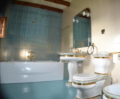 Elegante baño de estilo clásico con bañera de hidromasaje privada de una de las habitaciones dobles del hotel.