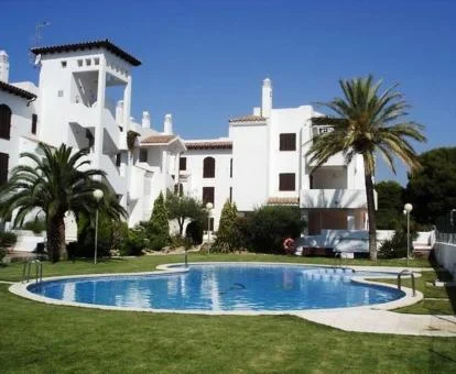 Hotel con encanto con amplia piscina rodeada de jardines.