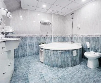 Amplio baño con bañera de hidromasaje privada de la suite deluxe del hotel.