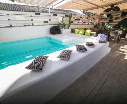 Coqueta terraza con piscina y mobiliario de este acogedor hotel.
