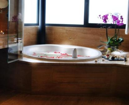 Bañera de hidromasaje circular con pétalos de flores de la Suite Grand.