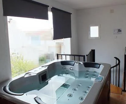 Foto del gran jacuzzi para cuatro personas con mutitud de orificios para chorros de hidromasaje en la habitación Deluxe con spa de la Pensión Isla