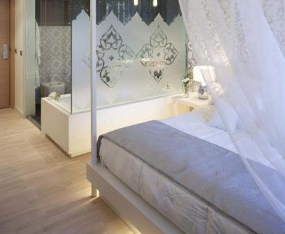 Habitación Deluxe con bañera de hidromasaje cerca de la cama.