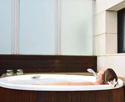 Mujer disfrutando del jacuzzi privado en la terraza de la Suite del hotel.