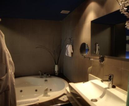 Baño con bañera de hidromasaje privada de la habitación deluxe del hotel.