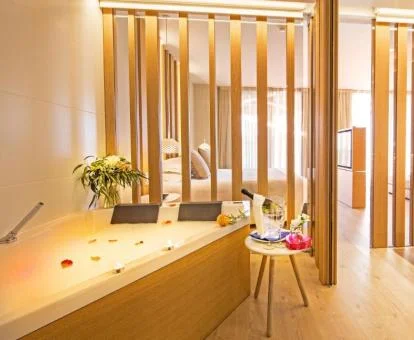 Suite Deluxe con vistas al mar y bañera de hidromasaje privada cerca de la cama.