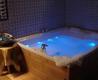 Suite con una fabulosa bañera de hidromasaje privada cerca de la cama.