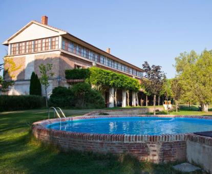 Precioso edificio de este hotel con amplios jardines y piscina al aire libre.