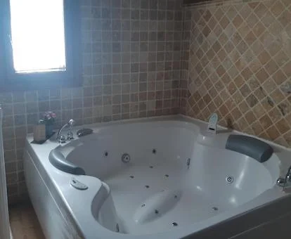 Baño con bañera de hidromasaje privada de la Habitación Doble Deluxe.