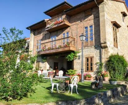 Edificio de este hotel con encanto con jardín y mobiliario exterior.