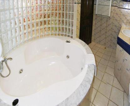 Baño con bañera de hidromasaje privada de la habitación doble deluxe del alojamiento.