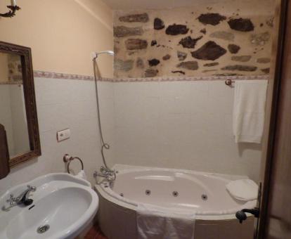 Baño con bañera de hidromasaje privada de la Habitación Doble Deluxe.