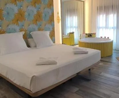 Preciosa Suite Deluxe con bañera de hidromasaje junto a la cama.