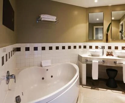 Baño con un amplio jacuzzi privado en la Suite Junior del hotel.