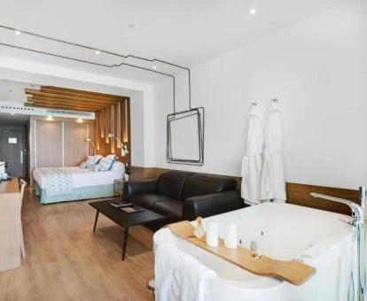 Suite Junior con vistas al mar y bañera de hidromasaje privada cerca de la cama.