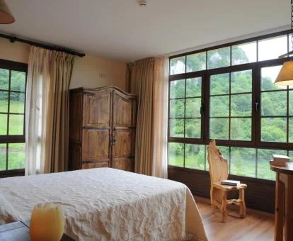 Una de las acogedoras habitaciones dobles con amplias cristaleras y vistas a la naturaleza del hotel.