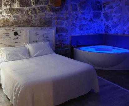 Dormitorio con bañera de hidromasaje privada junto a la cama de este hotel con encanto.