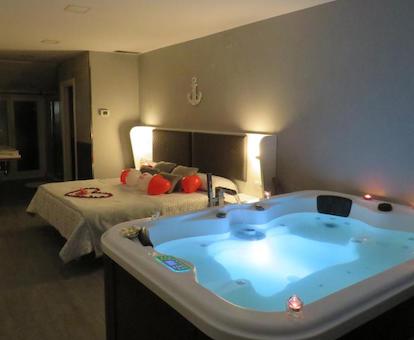 Precioso jacuzzi con burbujas de hidroterapia y luz azul que se encuentra junto a la cama de la Habitación Doble Deluxe.