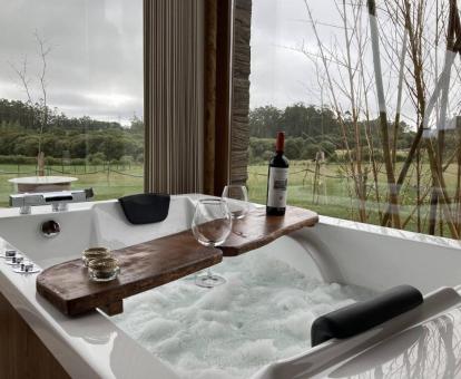 Fabulosa bañera de hidromasaje privada para dos personas con vistas a la naturaleza de una de las suites del hotel.