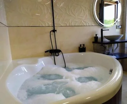 Bañera de hidromasaje privada de la Suite Deluxe del alojamiento.