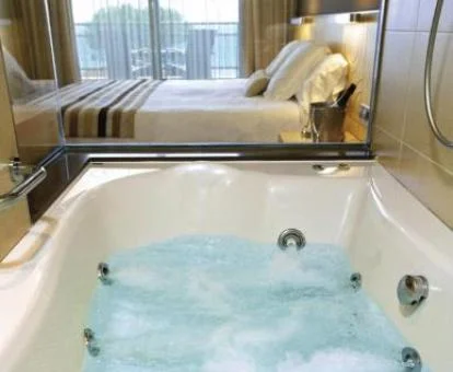 Jacuzzi en funcionamiento junto a la cama de la Habitación Doble Superior con vistas al mar.