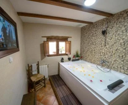 Espacio de bienestar privado con un gran jacuzzi privado de una de las casas rurales del alojamiento.