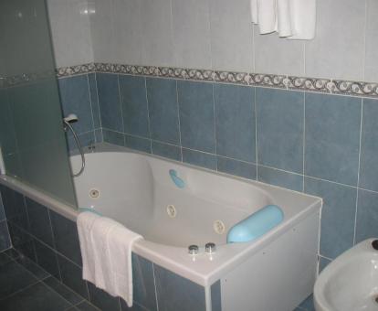 Baño con bañera de hidromasaje privada de la habitación doble superior del hotel.