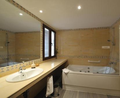 Baño con bañera de hidromasaje privada de una de las habitaciones dobles del hotel.