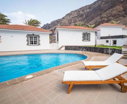 Zona exterior común con piscina y solarium de este complejo de bungalows.