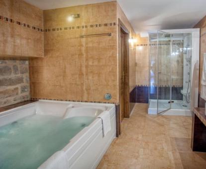Baño con un gran jacuzzi privado y ducha de hidromasaje de la Suite Junior del hotel.