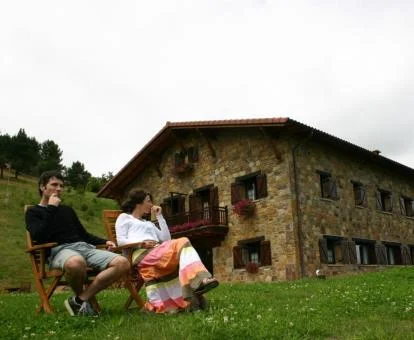 Pareja disfrutando del buen tiempo en el jardín de este precioso hotel rural.