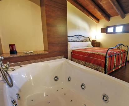 Dormitorio del dúplex con bañera de hidromasaje junto a la cama.