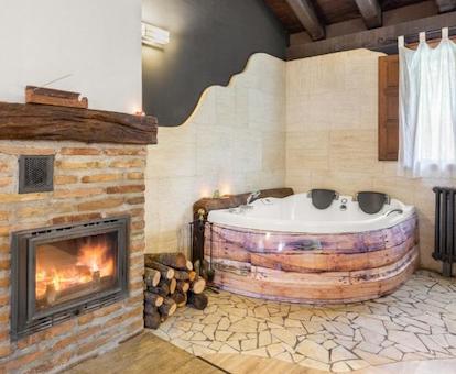 Amplia bañera de hidromasaje privada de una las suites con chimenea y jacuzzi en la Casa Rural Senderuela