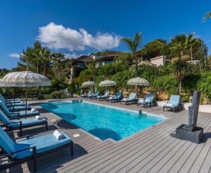 Zona exterior con piscina rodeada de tumbonas y vegetación de este hotel con encanto.