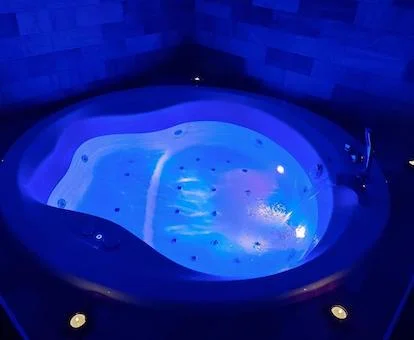 Suite Deluxe con bañera de hidromasaje cerca de la cama.