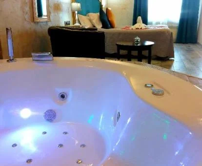 Suite Deluxe con bañera de hidromasaje cerca de la cama.