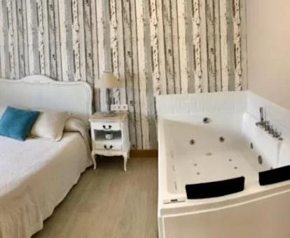 Habitación Doble con bañera de hidromasaje cerca de la cama.